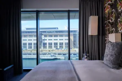 a bedroom with a large window with a view of a harbor at Malmaison Liverpool in Liverpool