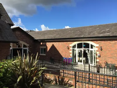 a brick house with a fence in front of it at The Villa Country House Hotel in Wrea Green