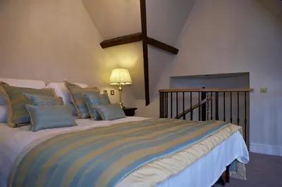 a bedroom with a large bed with blue pillows at The Villa Country House Hotel in Wrea Green