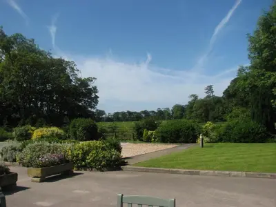 a garden with bushes and flowers and a pathway at The Villa Country House Hotel in Wrea Green