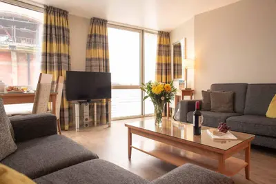 a living room with a couch and a table at PREMIER SUITES Liverpool in Liverpool