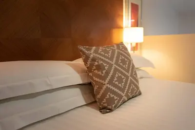a bedroom with a bed with a pillow on it at PREMIER SUITES Liverpool in Liverpool