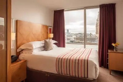 a hotel room with a bed and a large window at PREMIER SUITES Liverpool in Liverpool