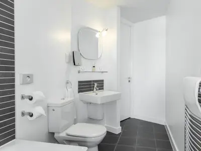 a bathroom with a toilet and a sink and a mirror at PREMIER SUITES Liverpool in Liverpool
