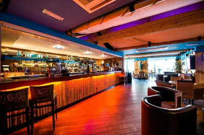 a restaurant with a bar with wooden floors and chairs at The Liner at Liverpool in Liverpool