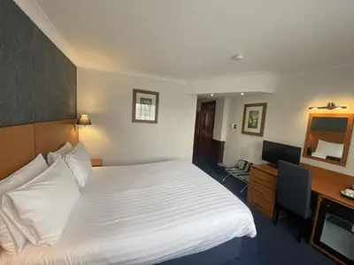 a hotel room with a bed and a desk and a television at The Liner at Liverpool in Liverpool