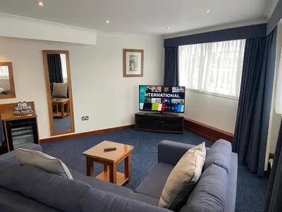 a living room with a couch and a flat screen tv at The Liner at Liverpool in Liverpool