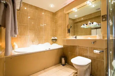 a bathroom with a tub and a toilet and a sink at The Liner at Liverpool in Liverpool