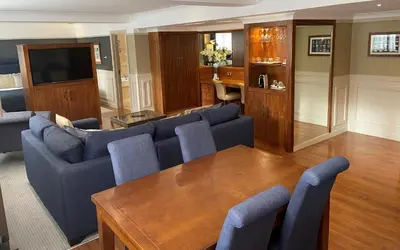 a living room with a blue couch and a wooden table at The Liner at Liverpool in Liverpool