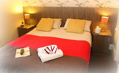 a hotel room with a bed with two towels on it at Glenheath Hotel in Blackpool