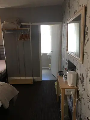 a room with a bedroom with a door and a mirror at Glenheath Hotel in Blackpool