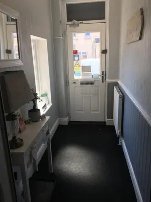 a hallway with a white door and a window at Glenheath Hotel in Blackpool
