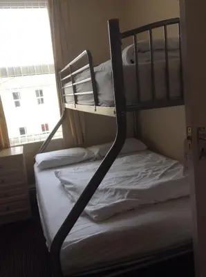 two bunk beds in a room with a window at Glenheath Hotel in Blackpool