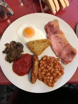 a plate of breakfast food with an egg and beans at Glenheath Hotel in Blackpool