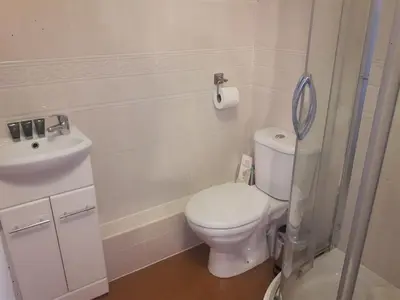 a white bathroom with a toilet and a sink at Lancaster Townhouse in Lancaster