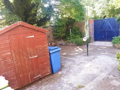 a small wooden shed next to a blue trash can at Lancaster Townhouse in Lancaster