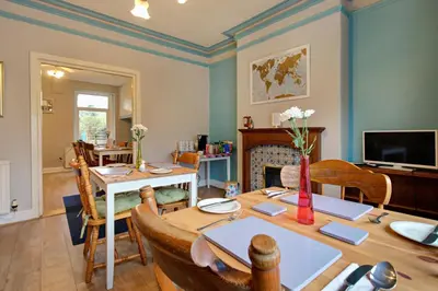 a dining room with a table and chairs and a television at Lancaster Townhouse in Lancaster