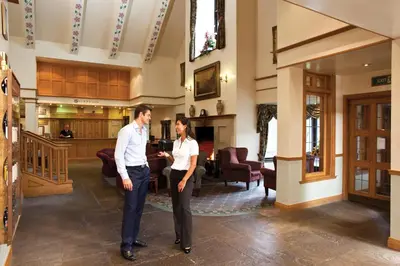 two men standing next to each other in a lobby at Lancaster House Hotel in Lancaster