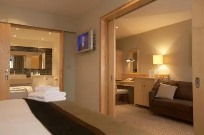 a hotel room with a bed and a living room at Lancaster House Hotel in Lancaster