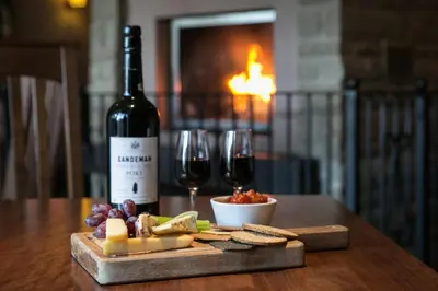 a bottle of wine and a plate of cheese and wine glasses at Lancaster House Hotel in Lancaster