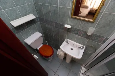 a bathroom with a toilet and a sink and a mirror at The Riviera Hotel in Blackpool