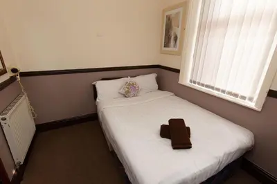 a small room with a bed with a brown object on it at The Riviera Hotel in Blackpool