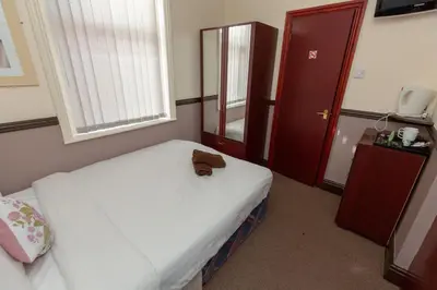 a small room with a bed and a window at The Riviera Hotel in Blackpool