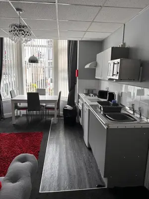 a kitchen with a table and a dining room at Berkswell Holiday Apartments in Blackpool