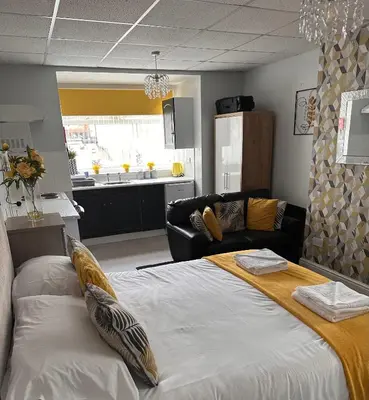 a bedroom with a large bed and a couch at Berkswell Holiday Apartments in Blackpool