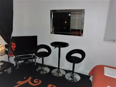 a living room with two stools and a television at Berkswell Holiday Apartments in Blackpool