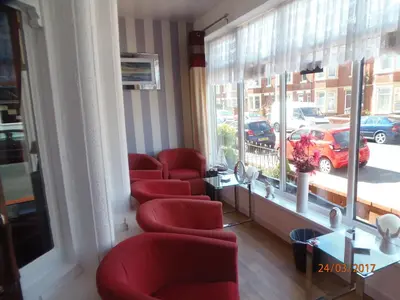 a waiting room with red chairs and a window at Oban House in Blackpool