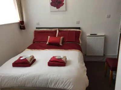 a bedroom with a bed with red towels on it at Oban House in Blackpool