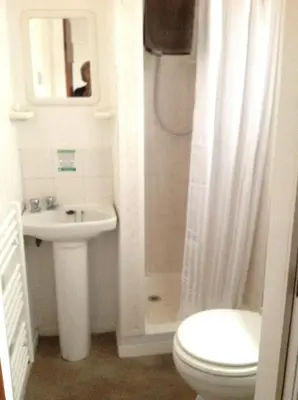 a white bathroom with a toilet and a sink at Oban House in Blackpool
