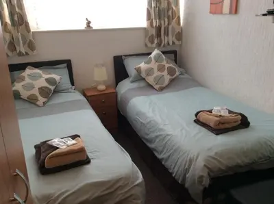 two beds in a room with towels on them at Oban House in Blackpool