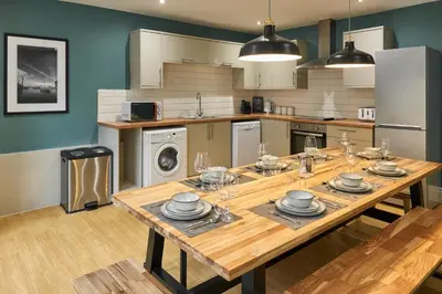 a kitchen with a wooden table with dishes on it at Host & Stay - The Georgian Quarters at Falkner Street in Liverpool