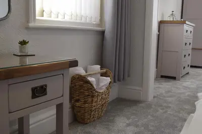 a bathroom with a sink and a basket with towels at Avenue Guest House in Blackpool