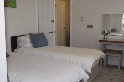 two beds in a hotel room next to a counter at Avenue Guest House in Blackpool