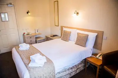 a hotel room with a bed with towels on it at Clifton Park Hotel - Adults Only in Lytham St Annes
