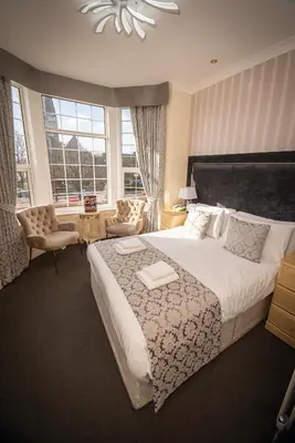 a bedroom with a large bed and a large window at Clifton Park Hotel - Adults Only in Lytham St Annes