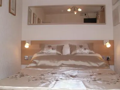 a bedroom with a large bed with a large mirror at Seaforth Guest House - Pleasure Beach in Blackpool