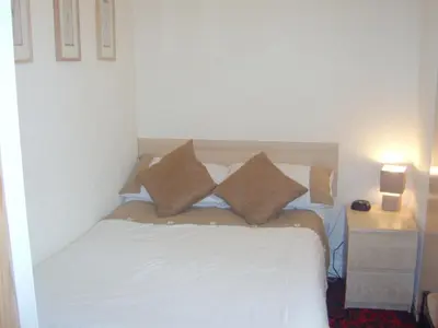 a bedroom with a white bed with pillows on it at Seaforth Guest House - Pleasure Beach in Blackpool
