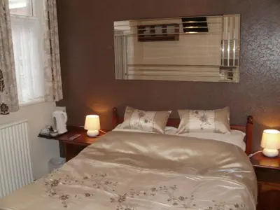a bedroom with a bed and two candles on tables at Seaforth Guest House - Pleasure Beach in Blackpool