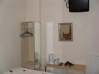 a bedroom with a dresser and a mirror and a bed at Seaforth Guest House - Pleasure Beach in Blackpool