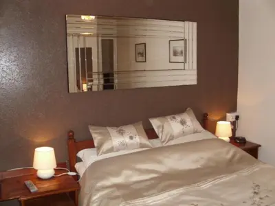 a bedroom with a bed with two lamps and a mirror at Seaforth Guest House - Pleasure Beach in Blackpool