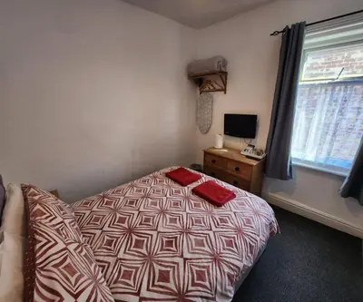 a bedroom with a bed and a window and a television at The Moorfield in Blackpool