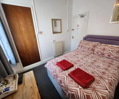 a bedroom with a bed with two red pillows on it at The Moorfield in Blackpool