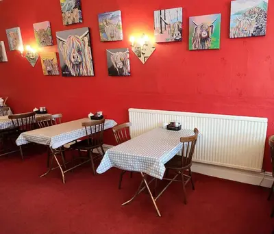 two tables and chairs in a restaurant with red walls at The Moorfield in Blackpool