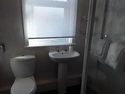 a bathroom with a toilet and a sink and a window at 140 Bond - Holiday Home in Blackpool