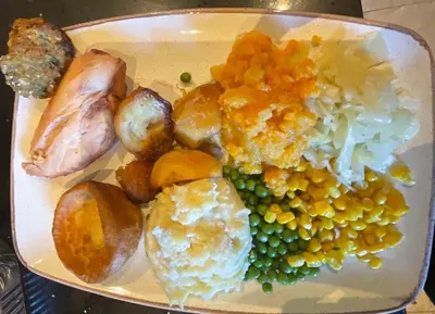 a plate of food with peas and other vegetables at The Pavilion Guest House in Millom