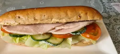 a sandwich with meat and vegetables on a plate at The Pavilion Guest House in Millom